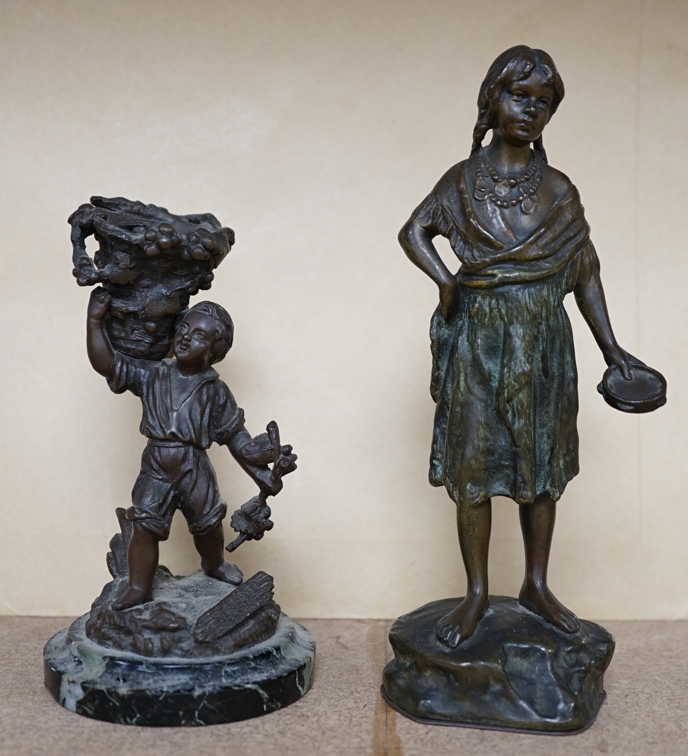 A bronze study of a girl holding a tambourine, and a bronze boy carrying grapes, raised on marble base, largest 16cm high. Condition - good